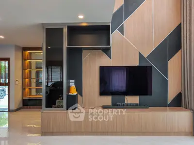 Modern living room with sleek TV unit and stylish geometric wall design