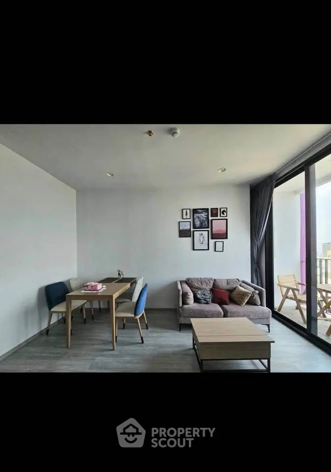 Modern living room with stylish decor and balcony access, featuring cozy seating and dining area.