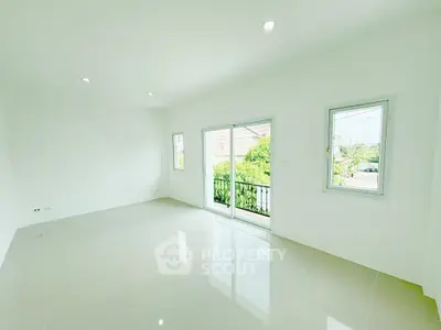 Spacious and bright empty room with large windows and sliding door to balcony, perfect for customization.