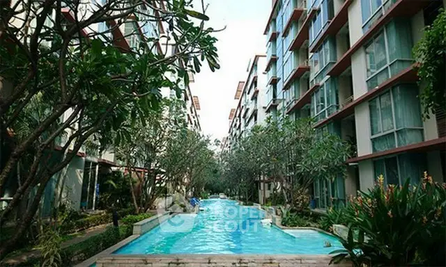 Luxurious apartment complex with stunning pool and lush greenery