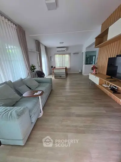 Spacious modern living room with stylish decor and large windows for natural light.