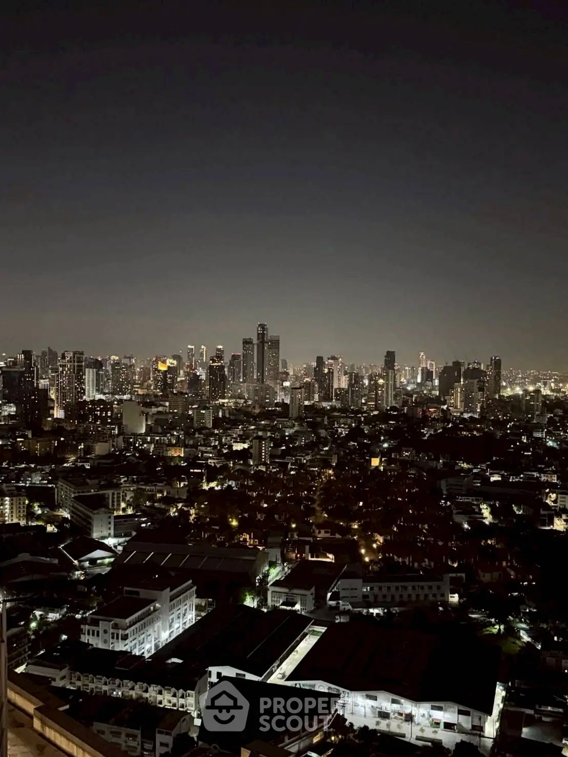 Stunning nighttime cityscape view showcasing a vibrant urban skyline with twinkling lights.