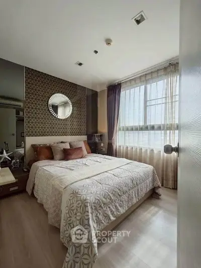 Cozy bedroom with stylish decor and large window offering natural light