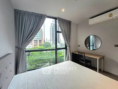 Modern bedroom with large window and city view, featuring a desk and air conditioning.