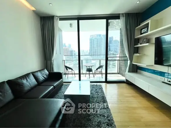 Modern living room with city view, featuring sleek furniture and a spacious balcony.