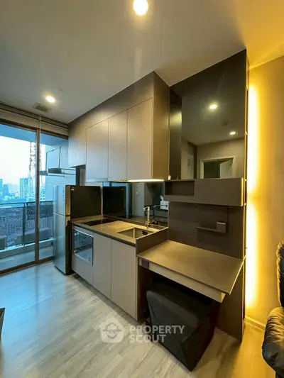 Modern kitchen with sleek cabinetry and city view from balcony