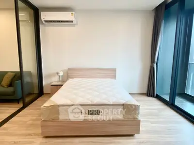 Modern bedroom with single bed, glass doors, and air conditioning in a stylish apartment.