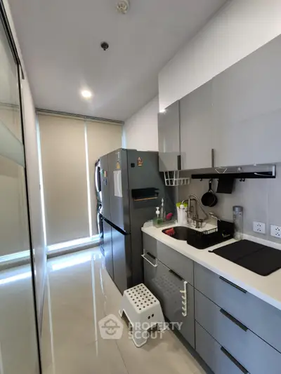 Modern kitchen with sleek cabinetry and stainless steel appliances in a compact layout.
