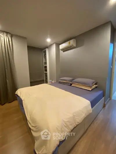 Cozy bedroom with modern decor and air conditioning in a stylish apartment.