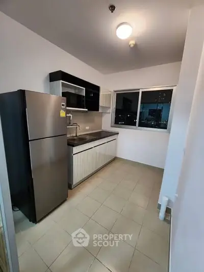 Modern kitchen with sleek cabinets and stainless steel fridge in urban apartment