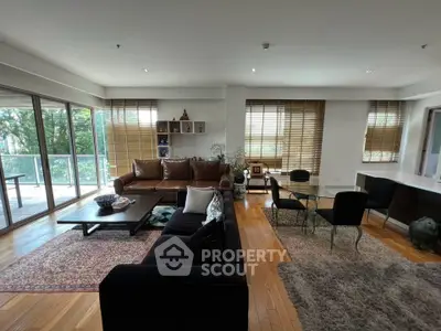 Spacious living room with large windows and stylish furniture, offering a cozy and inviting atmosphere.