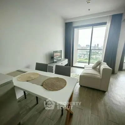 Modern living room with city view, stylish furniture, and large windows in a high-rise apartment.