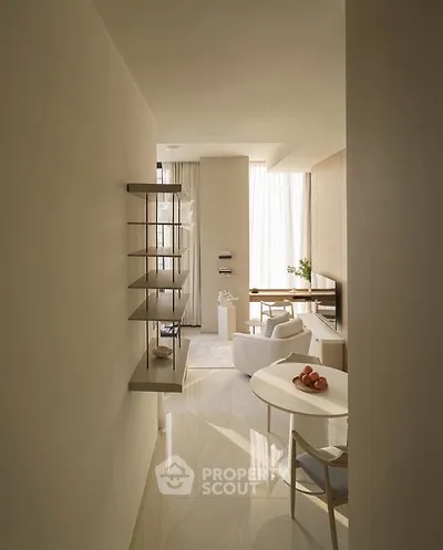 Elegant modern living room with minimalist decor and natural light, featuring a cozy dining area and stylish shelving.