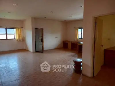 Spacious empty room with tiled flooring and large windows, ideal for customization.