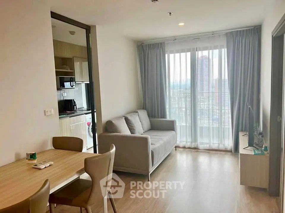 Modern living room with cozy sofa and dining area, featuring a view of the city through large windows.