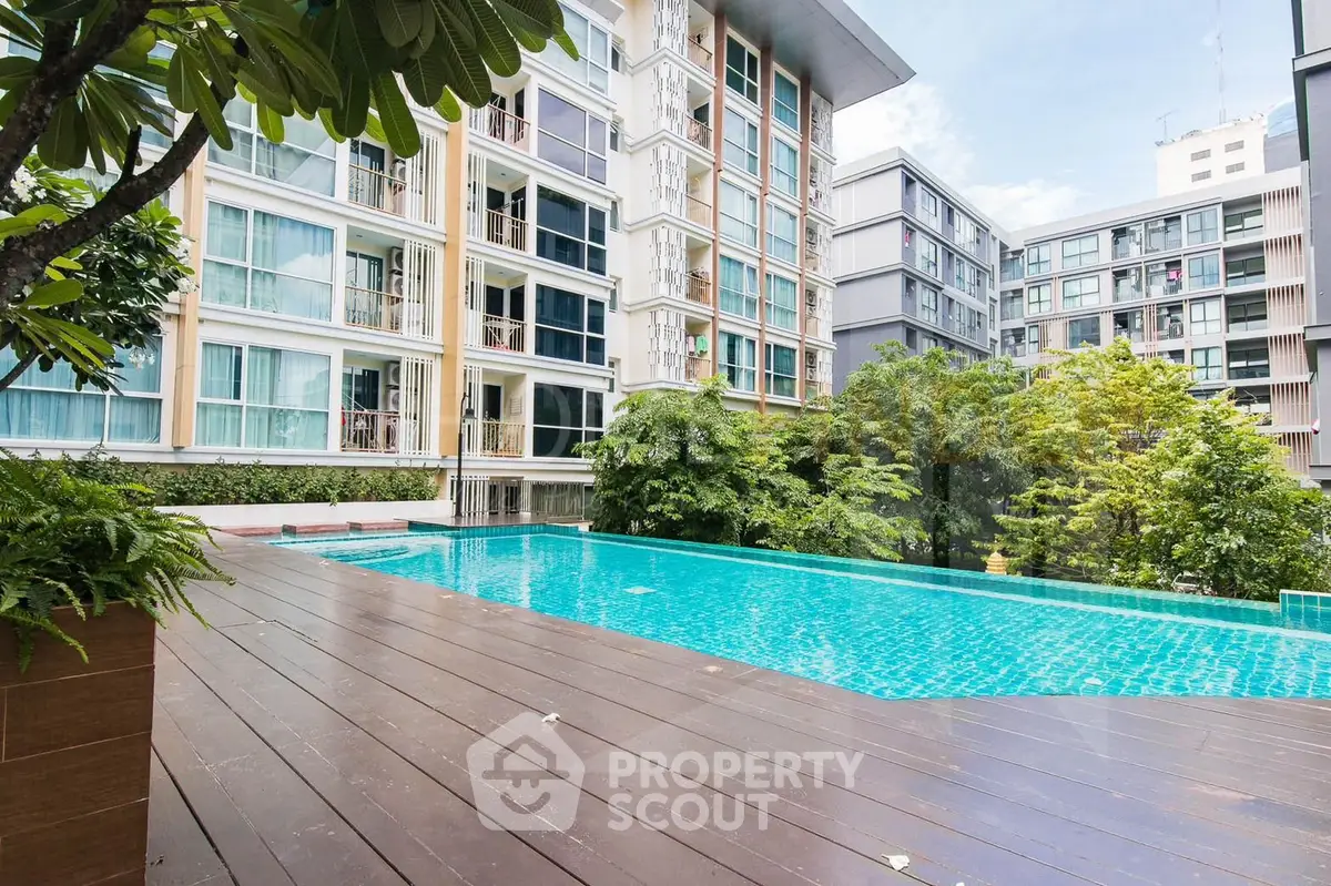 Luxurious condominium with stunning pool and lush greenery in urban setting.