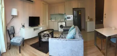 Modern living room with open kitchen, featuring sleek furniture and built-in appliances for stylish urban living.