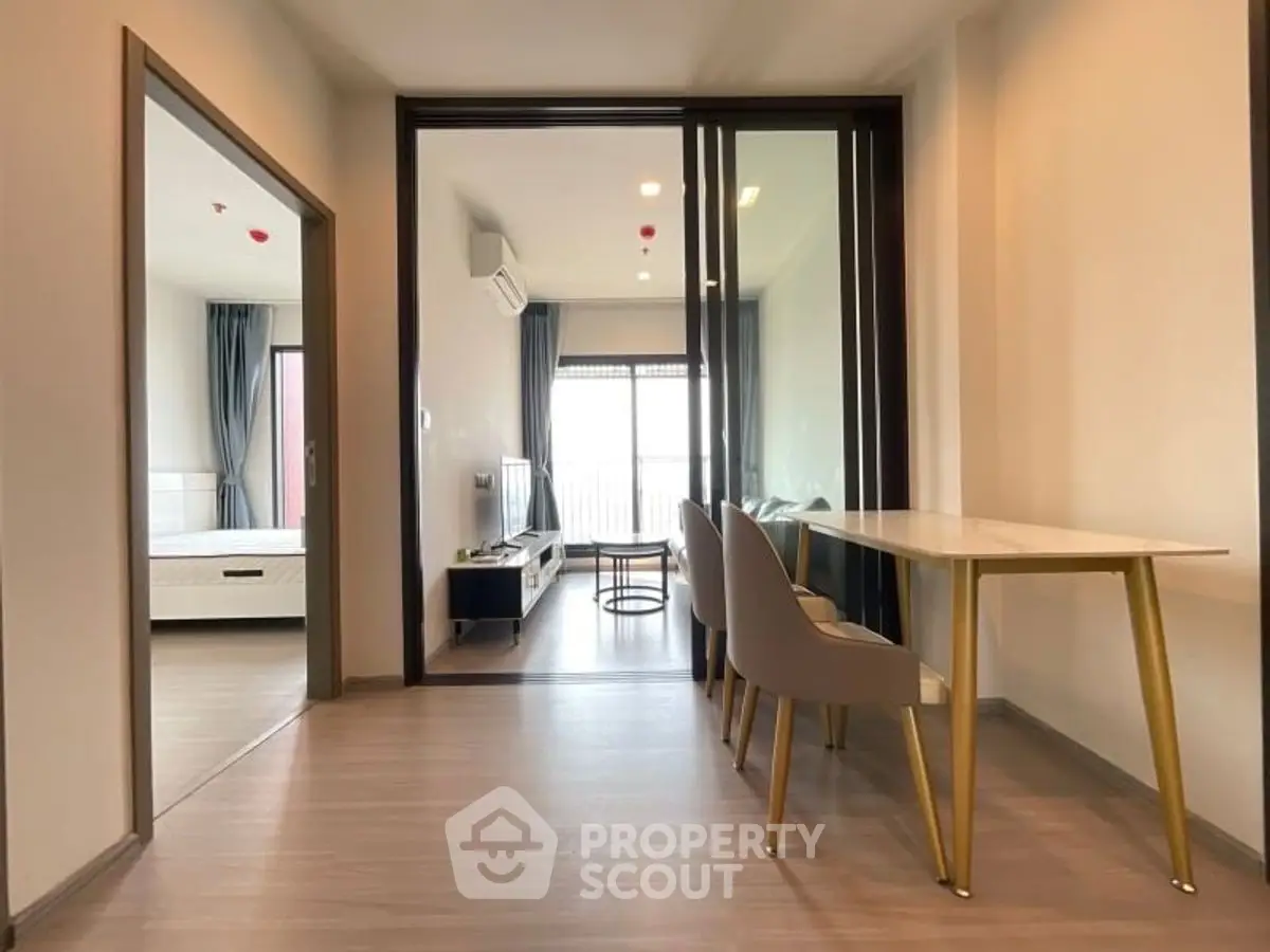 Modern apartment interior with open layout dining and living area, featuring sleek furniture.