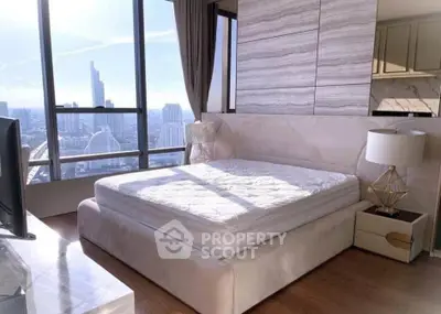 Luxurious bedroom with stunning city view and elegant decor in high-rise apartment.