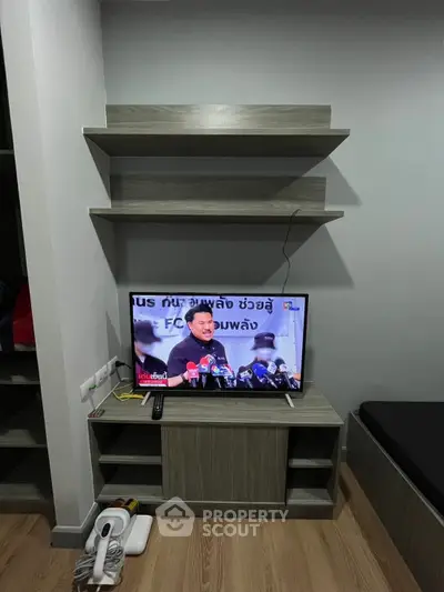 Modern living room with sleek TV unit and floating shelves, perfect for stylish urban living.