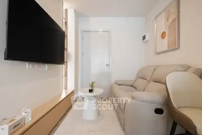 Modern living room with sleek design, featuring a comfortable sofa and wall-mounted TV.