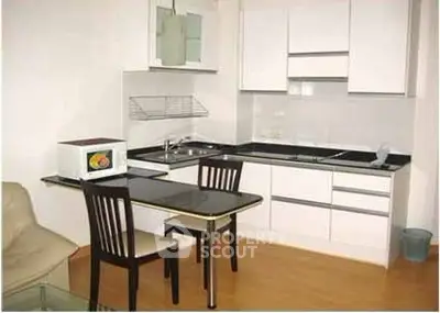 Modern compact kitchen with sleek white cabinets and dining area