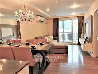 Spacious modern living room with elegant chandelier and large sofa in a stylish apartment.