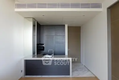Modern minimalist kitchen with sleek cabinetry and integrated appliances in a luxury apartment.