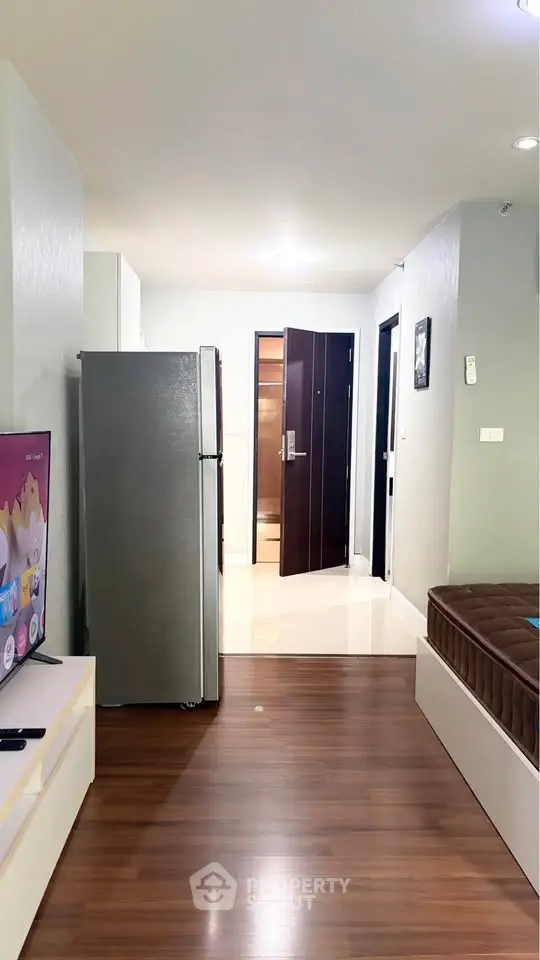 Modern apartment interior with sleek wooden flooring and contemporary furnishings, featuring a spacious open layout.