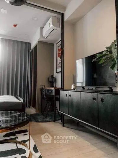 Modern living room with sleek furniture and stylish decor, featuring a TV and air conditioning.
