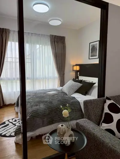 Cozy bedroom with modern decor and large window for natural light.