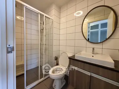 Modern bathroom with sleek shower and stylish vanity in contemporary apartment.