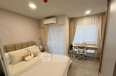 Cozy bedroom with modern decor and workspace, featuring large windows and soft lighting.