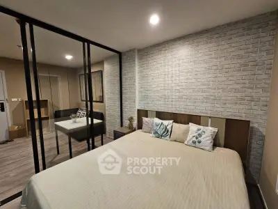 Modern bedroom with stylish brick accent wall and glass partition for a chic urban living experience.