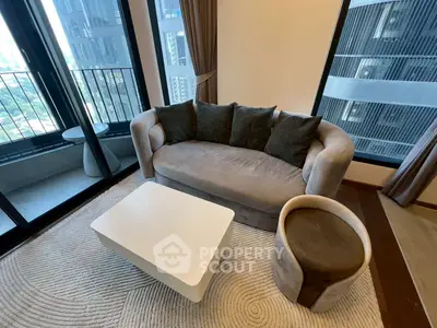 Stylish living room with modern furniture and balcony view in a high-rise apartment.