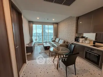 Modern living room with open kitchen and stunning city view from balcony.