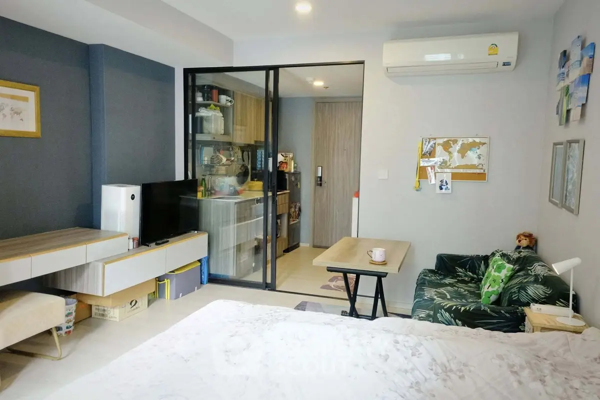 Modern studio apartment with open layout and stylish decor, featuring a cozy living area and compact kitchen.