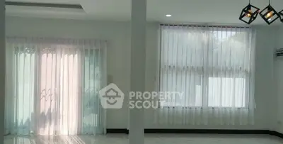 Spacious living room with large windows and elegant curtains in a modern home.