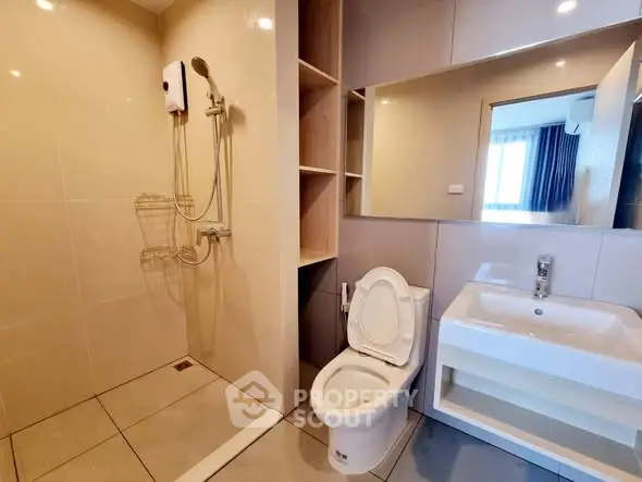 Modern bathroom with sleek fixtures and spacious shower area in a contemporary apartment.