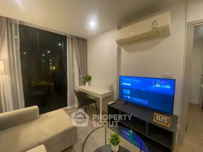 Modern living room with cozy seating, large TV, and stylish decor in a high-rise apartment.
