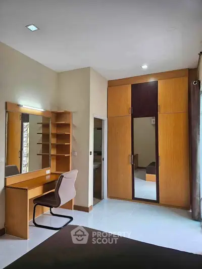 Spacious bedroom with built-in wardrobe and study desk, perfect for modern living.