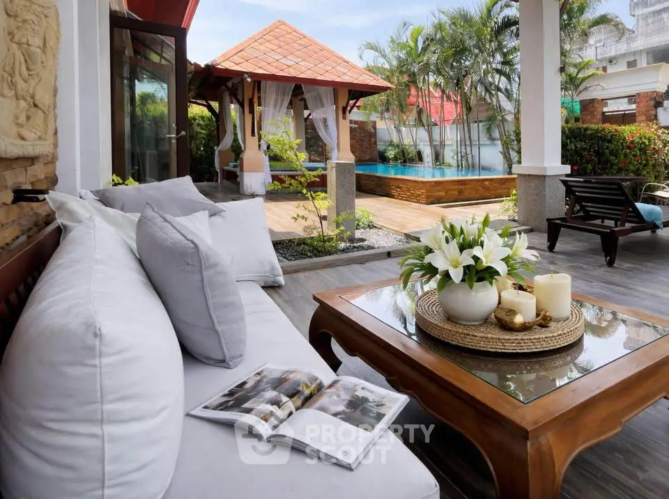 Luxurious outdoor patio with pool view, elegant seating, and tropical landscaping for ultimate relaxation.