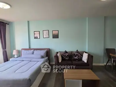 Modern studio apartment with cozy bed and stylish sofa in open layout.