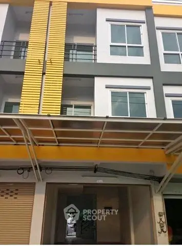 Modern three-story building with contemporary design and large windows.