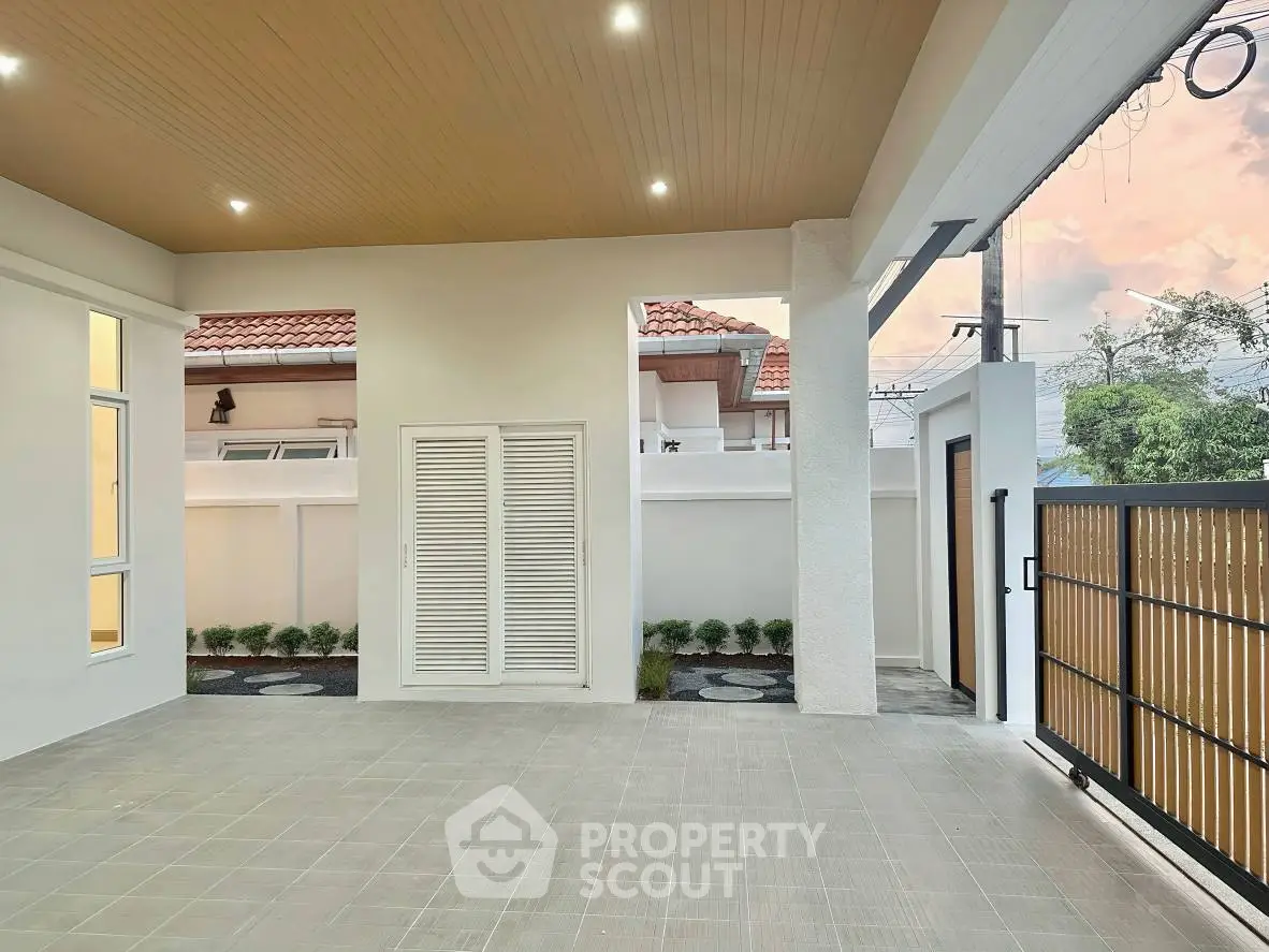 Spacious modern patio with elegant lighting and secure gated entrance, perfect for outdoor relaxation.