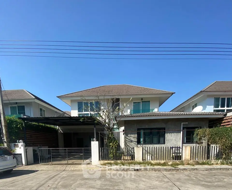 Charming suburban house with modern design and spacious driveway under clear blue sky.