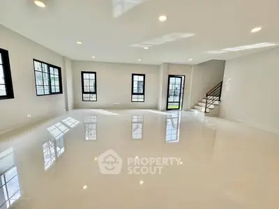 Spacious modern living room with large windows and glossy tiled floors