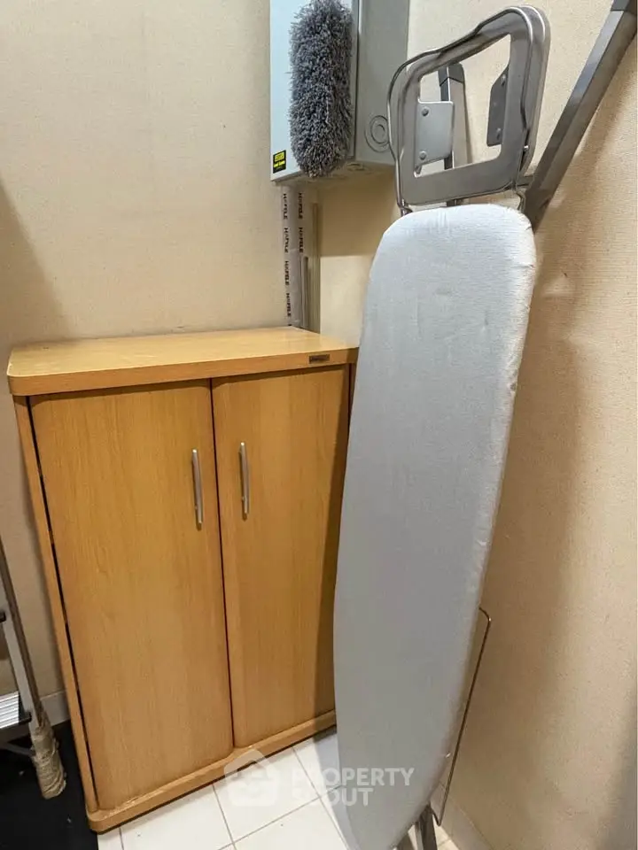 Compact storage area with ironing board and cabinet, ideal for efficient home organization.