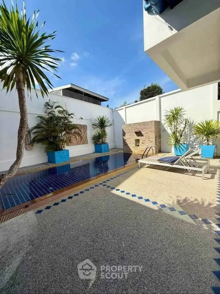Luxurious outdoor pool area with modern design and lush greenery, perfect for relaxation and entertainment.
