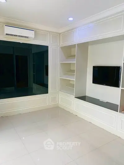Spacious living room with built-in shelves and modern TV setup